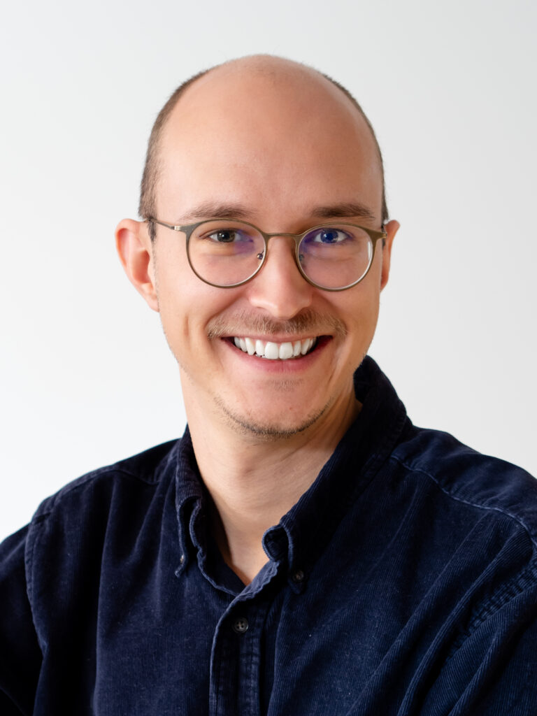 Lächelnde Person im Portrait, die eine warme und freundliche Ausstrahlung hat.